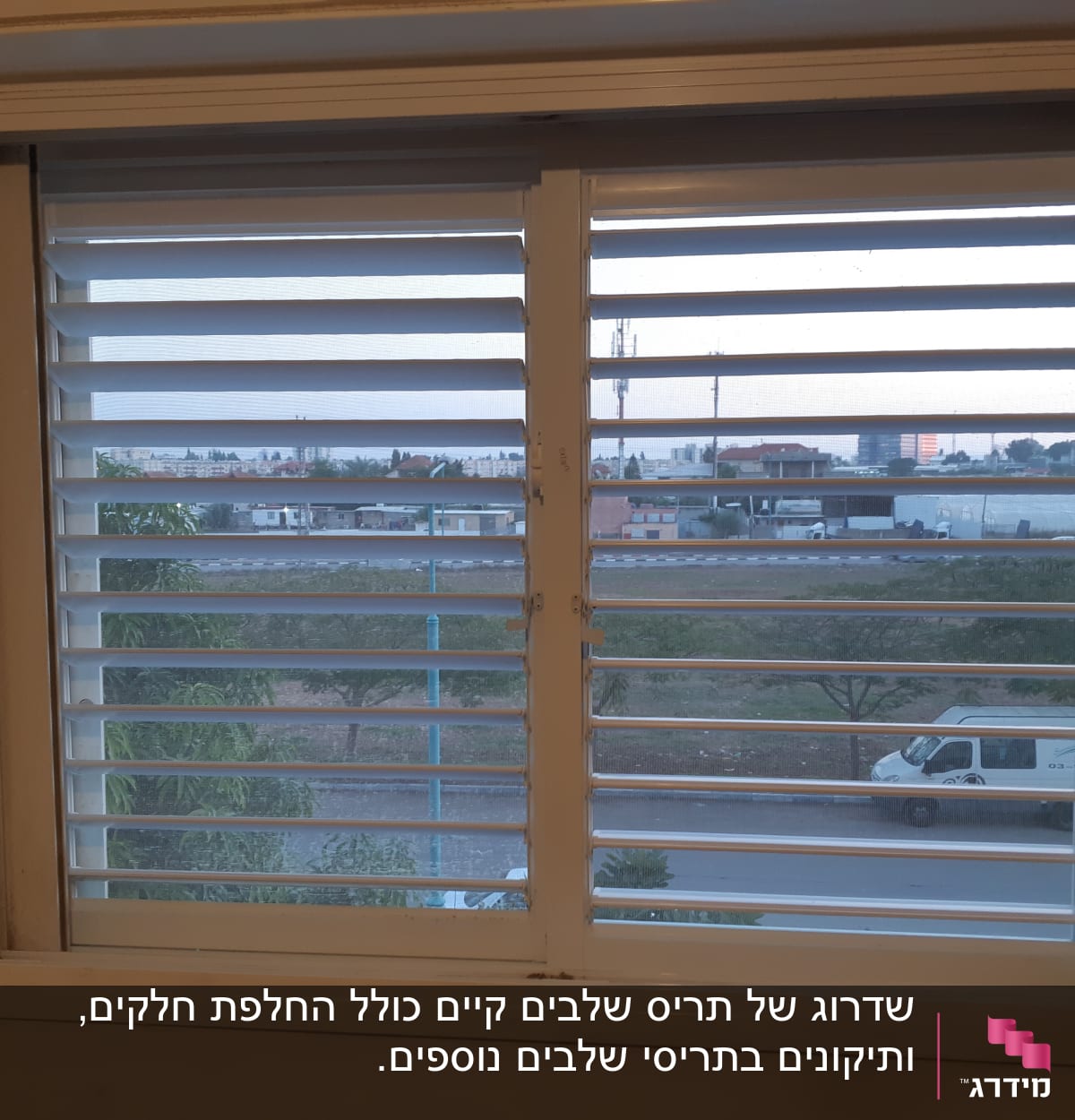 חלון עם תריסי אלומיניום פתוחים חלקית